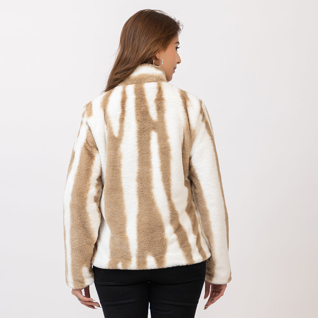 Woman wearing a beige and white patterned sweater on a plain background Amoldo