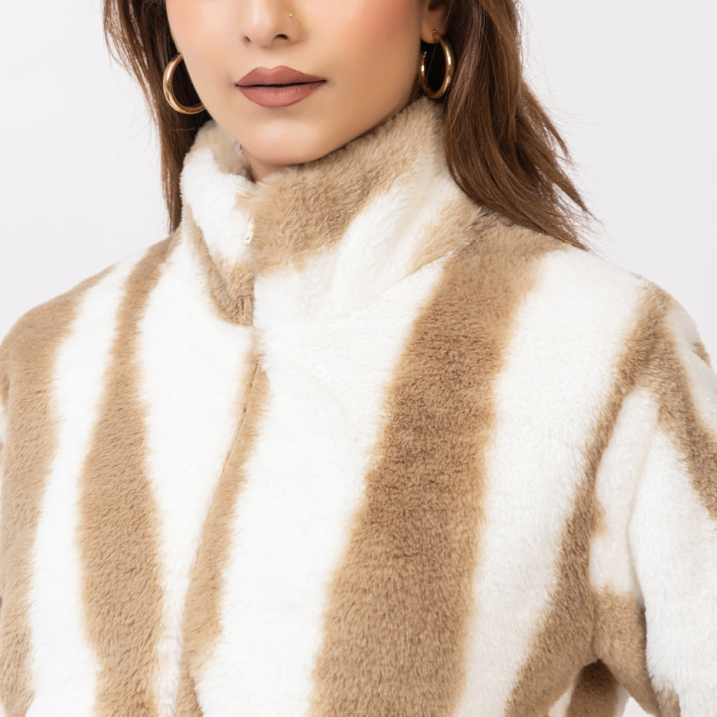 Woman wearing a beige and white patterned sweater on a plain background Amoldo
