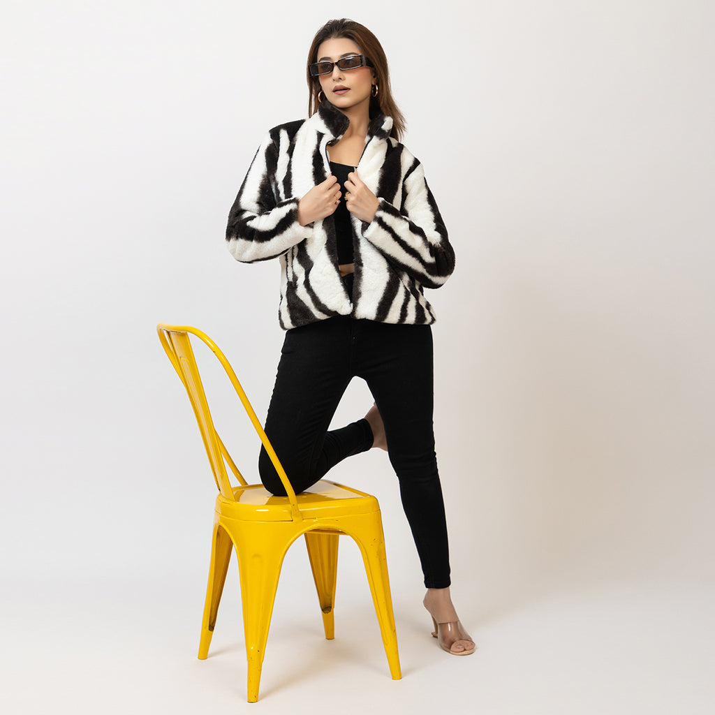 Woman wearing a black and white striped sweater on a plain background Amoldo
