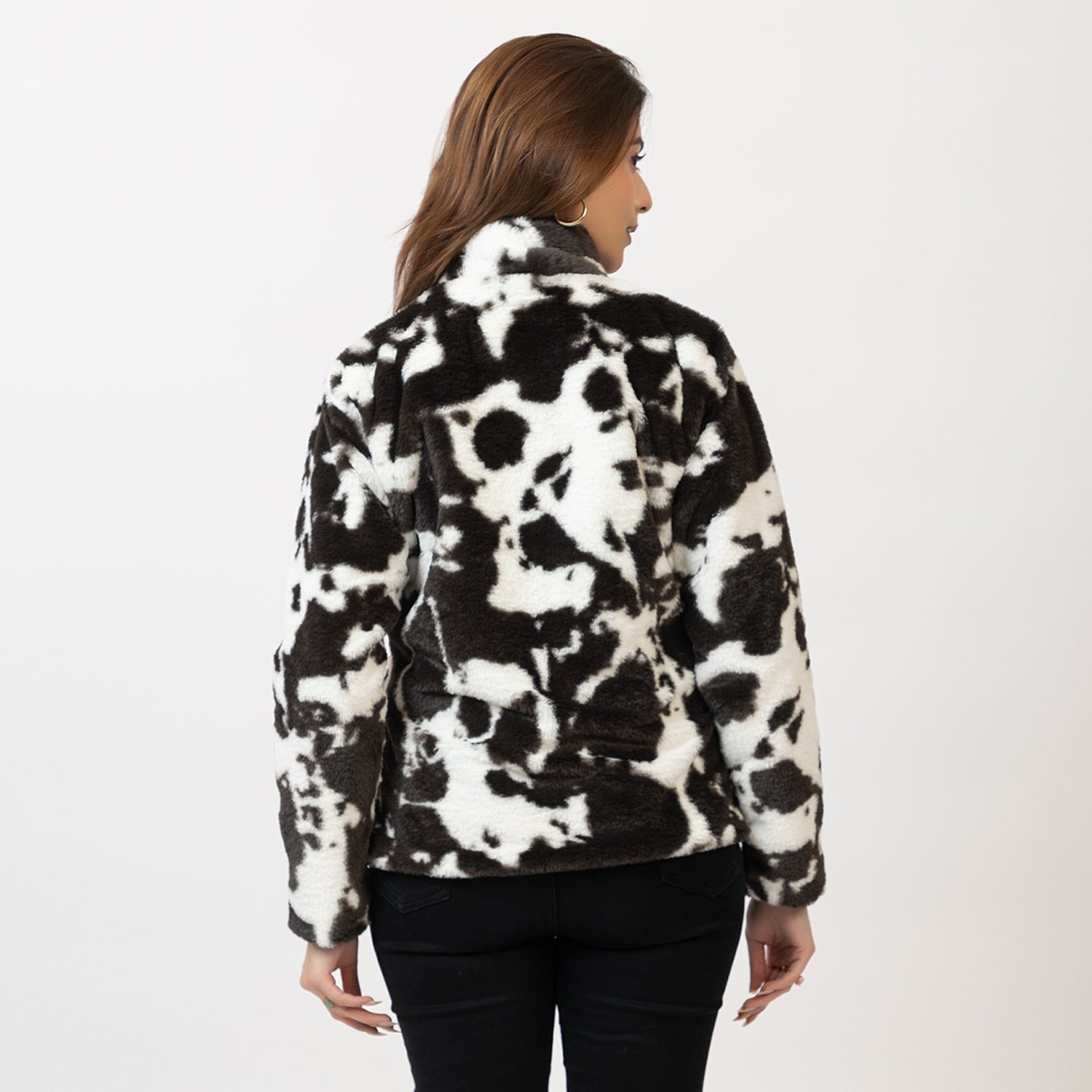 Person wearing a black and white patterned jacket on a plain Amoldo background