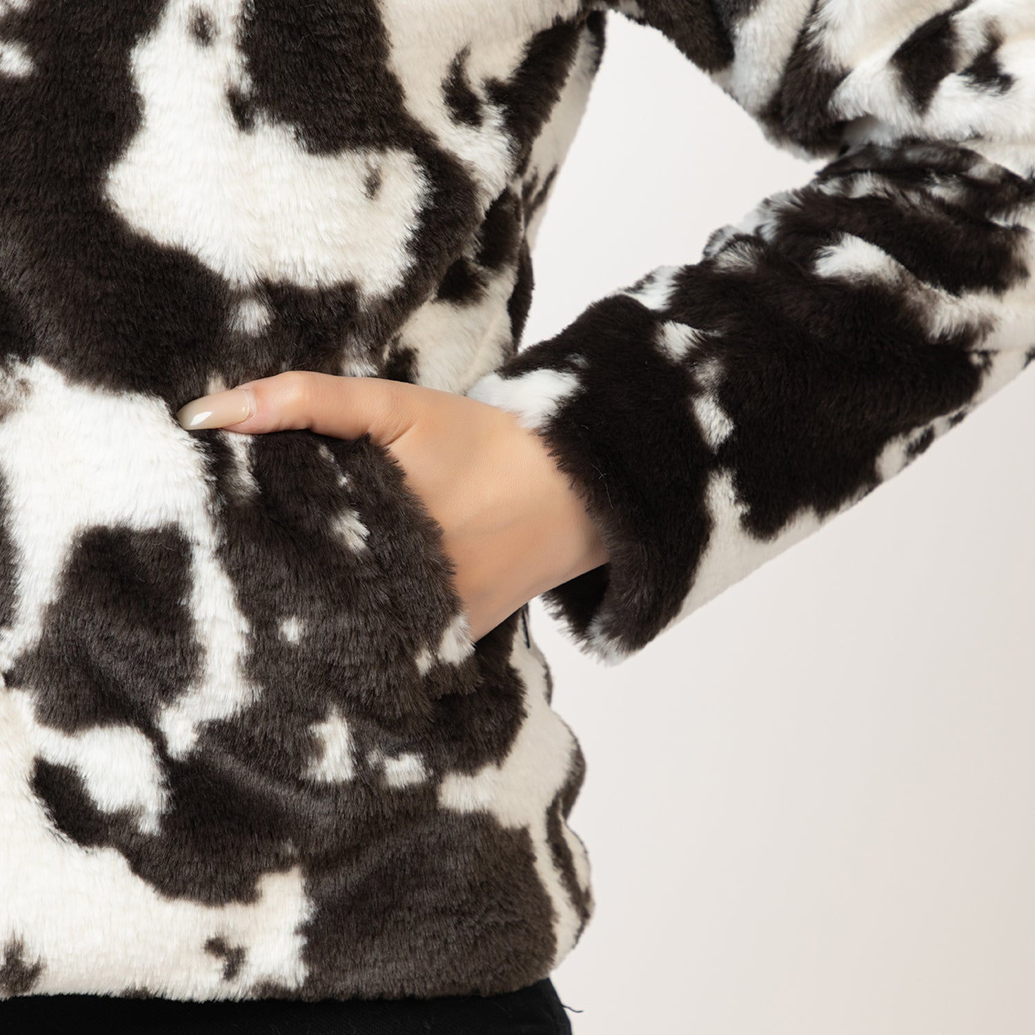 Close-up of a black and white patterned fabric with a hand touching it. Amoldo 