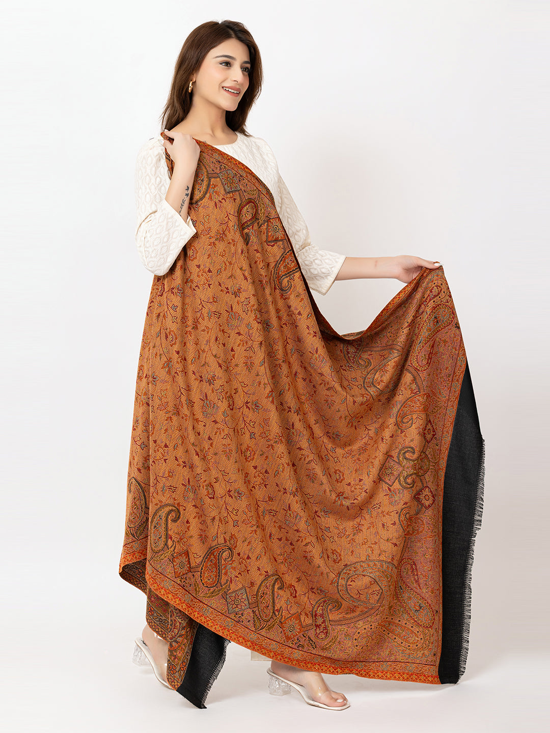  Amoldo Woman holding a large brown patterned scarf against a white background